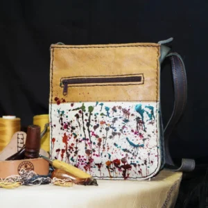 paint splatter tan leather sling bag